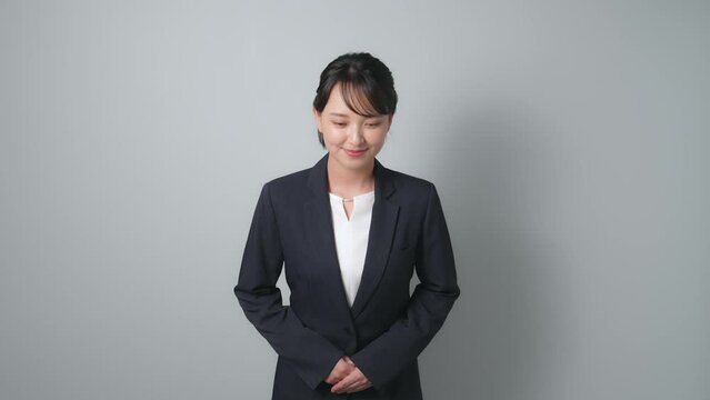 お辞儀するスーツを着た女性