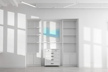 Shelving unit, chest of drawers and shadows on wall
