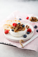 Baked camembert cheese with nuts and berries