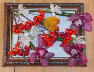 Red rowan berries on a rowan tree. orchid flowers. Yellow chrysanthemum flower, lilies.Still life...