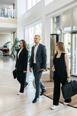 Business people enter the lobby of a business office or hotel. Concept of business negotiations, services. conducting presentations and business gatherings and business travel.