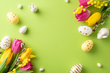 Easter joy captured from above. Top view photo of tulips, mimosa, pussy willow, multicolored eggs,...