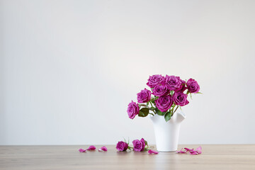 purple roses in vase on white background