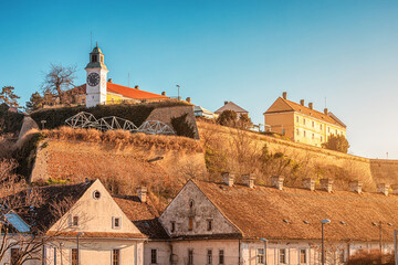 the ancient walls of Petrovaradin Fortress and its timeless clock tower stand as a testament to Serbian history, inviting tourists to explore its cultural significance and scenic vistas. - obrazy, fototapety, plakaty