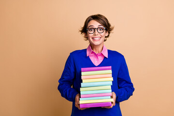 Photo of intelligent positive person hands hold pile stack book empty space isolated on beige color...
