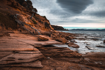 The view of the Painted Cliffs in Maria Island in Tasmania under the storm clouds