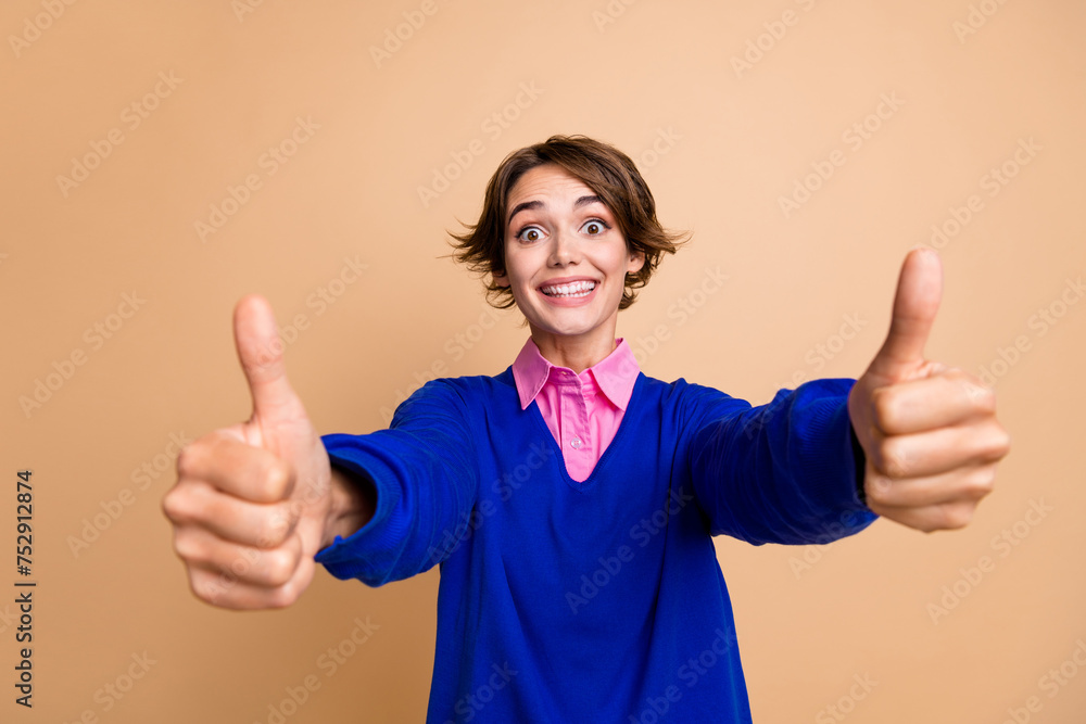 Poster Photo portrait of lovely young lady show double thumb up approve dressed stylish blue garment isolated on beige color background