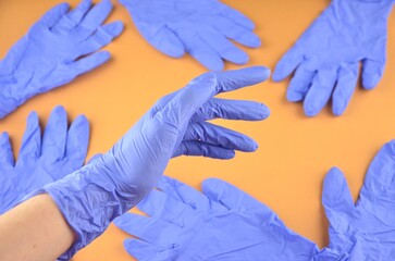 A bunch of blue latex medic (medical) gloves on an orange background