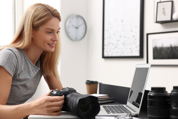 Professional photographer with digital camera at table in office