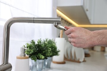 Plumber repairing faucet with spanner indoors, closeup