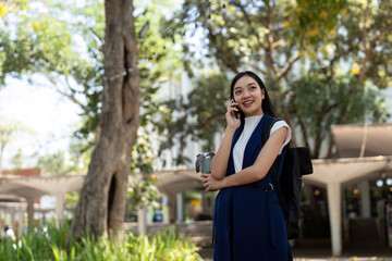 Young happy Asian business woman office professional talk cellphone in walking on city go work