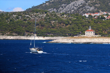 Sailing boat and picturesque lighthouse near town Hvar, on island Hvar, Croatia.