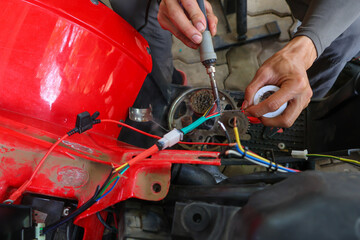 selective focus wires in the hand of a car mechanic Practicing repairs to the ATV's electrical system. Wires of various colors help you know the direction of your car's electrical system.