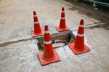 Concrete road on damaged bridge There is an orange cone placed around it as a symbol.