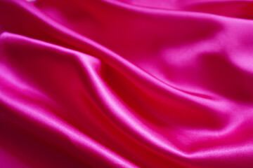 Pink silk or satin background, wavy, elegant and elegant. Close-up, background. Space for designblur or blurry