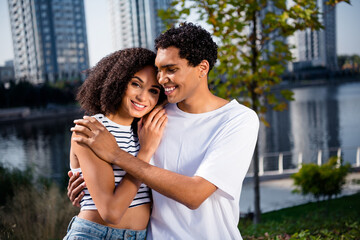 Fototapeta premium Photo of adorable good mood wife husband wear casual clothes cuddling enjoying river bank view outside urban city street