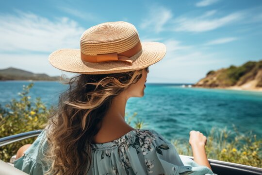 Side view of young woman in straw hat sitting in cabriolet and looking at sea