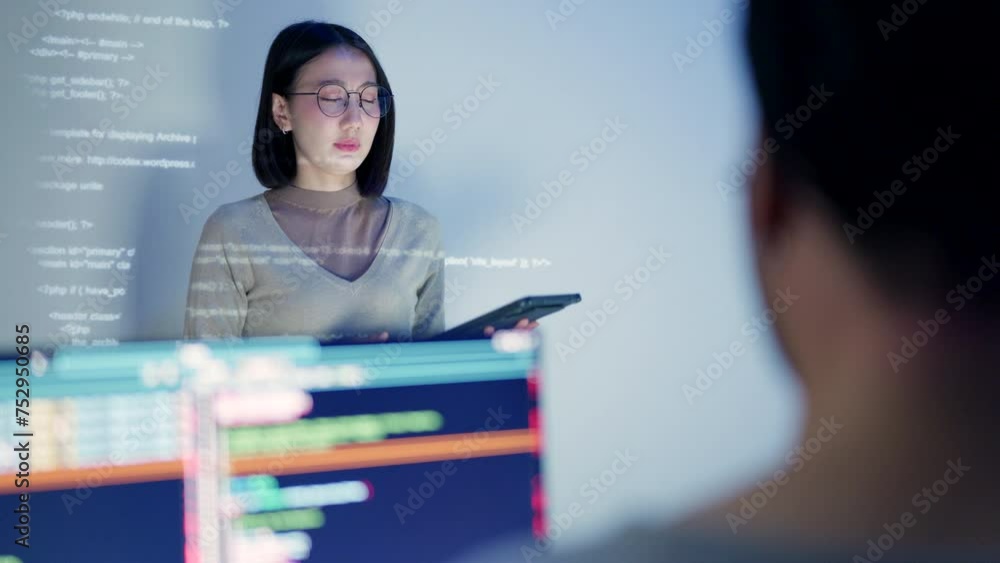 Wall mural a female software developer leads a tech discussion, her face lit by the projection of html code as 