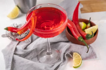 Keuken spatwand met foto Spicy hot chili peppers margarita cocktail with lime and bar utensils on kitchen table, copy space © ricka_kinamoto