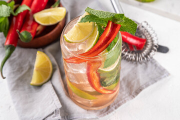 Thai cold red chili iced tea, lemonade  or mojito cocktail glass, summer asian refreshment drink with lime, mint and chili pepper