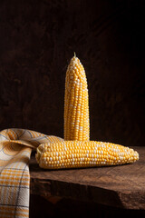 Two cobs sweet corn on wooden background..