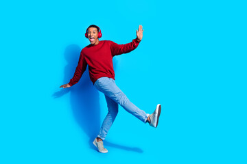 Fototapeta premium Photo of positive nice good mood man wear red trendy pullover listen upbeat music club disco isolated on blue color background