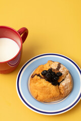 A scone and white milk on a yellow background