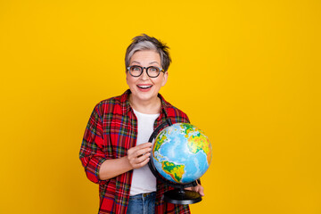 Photo of astonished positive person hands hold world globe empty space isolated on yellow color...