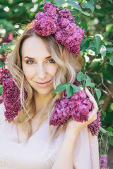 Beautiful woman surrounded by lilac blooms, spring freshness - 752967622