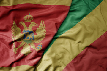 big waving national colorful flag of republic of the congo and national flag of montenegro .