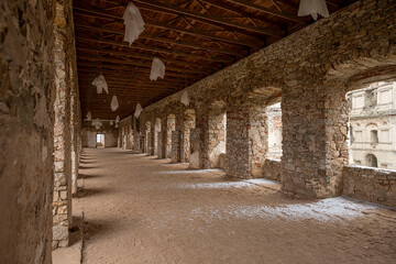 Interior of an old building with arches and stone walls.