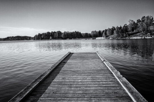 Wooden jetty on the lake in Sweden. Black and white photo.