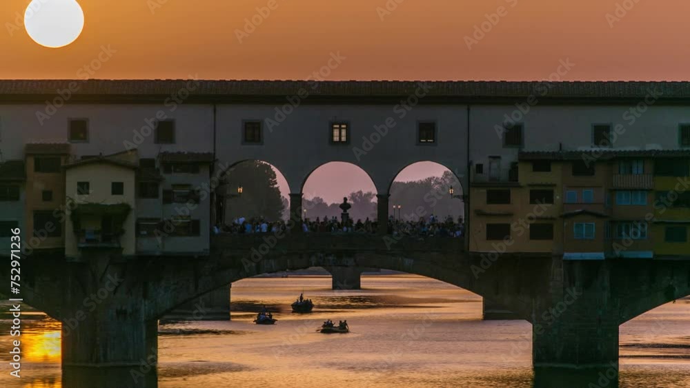 Wall mural Sunset view of Florence Ponte Vecchio over Arno River in Florence timelapse, Italy. Florence architecture. One of the main landmarks in Florence. Close up view with orange sky