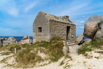 Fototapeta na wymiar L'ancien corps de garde des Amiets, emblème du passé maritime du Finistère nord, surplombe la plage, rappelant l'histoire de la Bretagne en un clin d'œil.