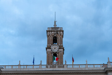 A clock tower with a flag on top of it