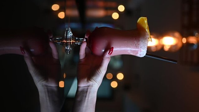 Bartender woman serves Cocktail into a transparent glass