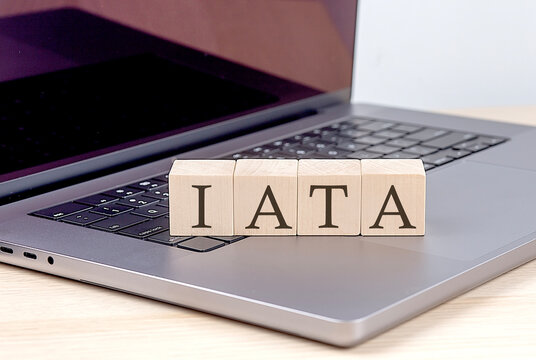 IATA word on wooden block on laptop, business concept