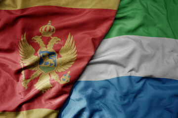 big waving national colorful flag of sierra leone and national flag of montenegro .