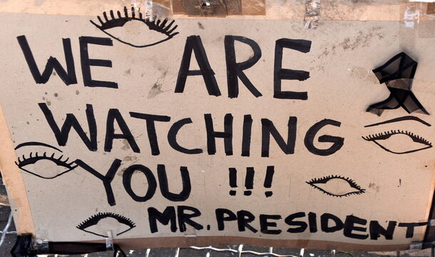 Pappschild: "We are watching you !!! Mr. President"