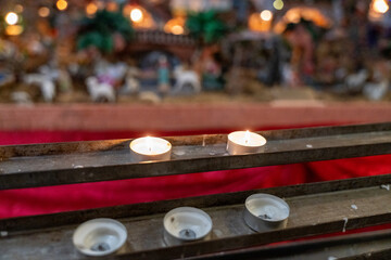A row of candles are lit on a red background