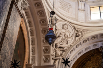 A silver lantern hangs from the ceiling of a church