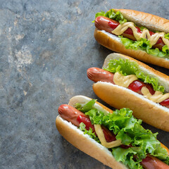 Delicious hot dogs with different toppings served on grey table, flat lay. Space for text