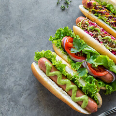Delicious hot dogs with different toppings served on grey table, flat lay. Space for text