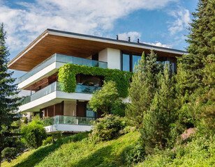 Modern house in the forest covered with green vegetation