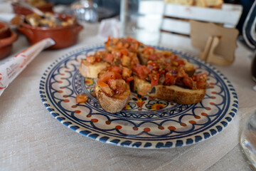 A plate of bread with tomato and onion toppings