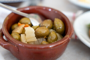 A bowl of food with olives and carrots