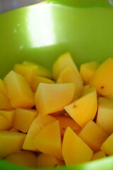 cut up melon sits in a green bowl on the counter