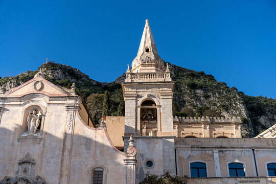 A church with a steeple and a mountain in the background