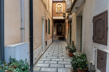 Fototapeta na wymiar A narrow alleyway with a white building on the left