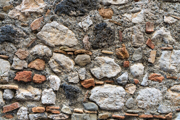 A wall made of stones and bricks with a variety of colors and textures